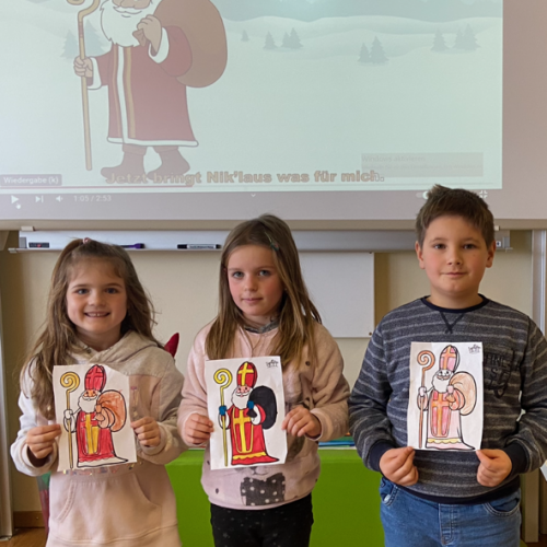 drei Kinder der ersten Klasse zeigen ihre Bilder vom Nikolaus